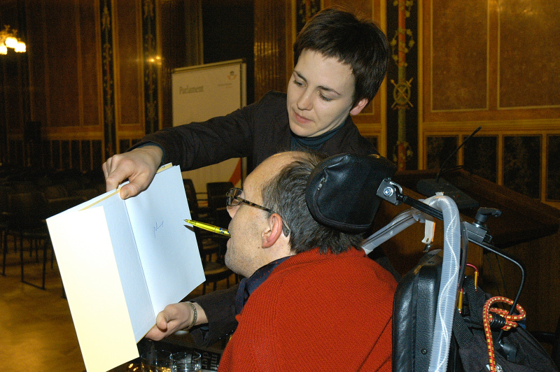 Franz-Josefph Huainigg (Autor) beim Signieren eines Buches.