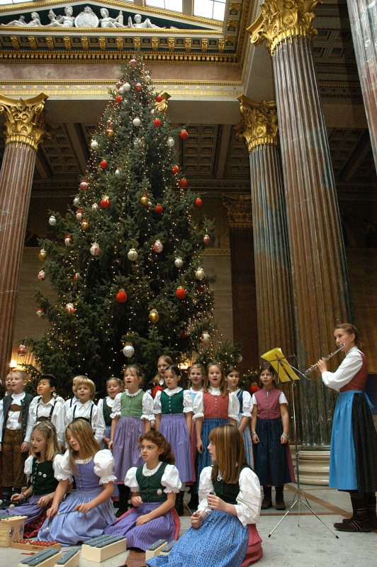 Der Kinderchor singt vor dem Weihnachtsbaum.