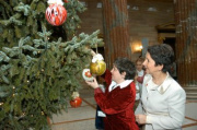 Barbara Prammer hängt mit einem Mädchen aus der Behindertenwerkstätte Hartheim eine Christbaumkugel auf.