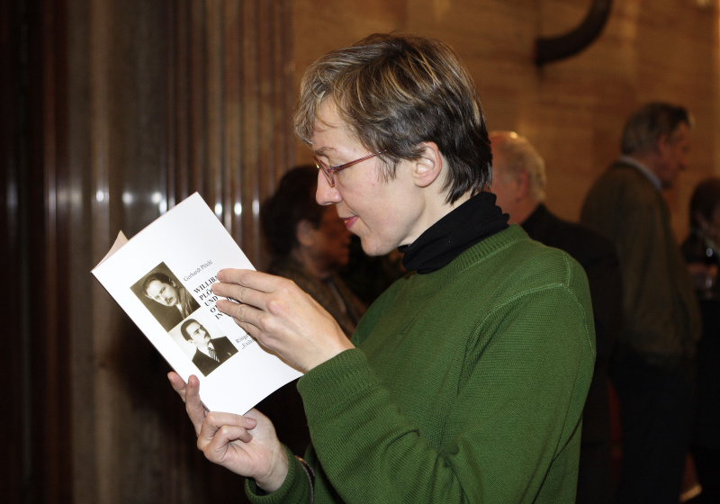 Veranstaltungsteilnehmer mit Buch in Händen.
