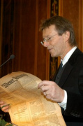 Herausgeber a.o. Univ.-Prof.MMag.DDr. Günther Löschnigg liest aus der Wiener Zeitung vor, am Rednerpult.