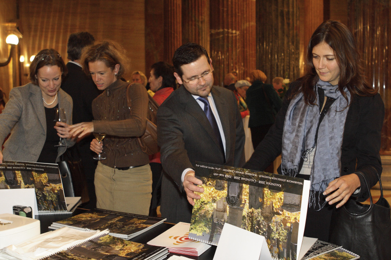 Veranstaltungsteilnehmer betrachten den Fotokalender.