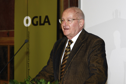 Manfried Welan (ehem. Rektor der BOKU) mit Mikrofon vor Tafel und Leinwand.