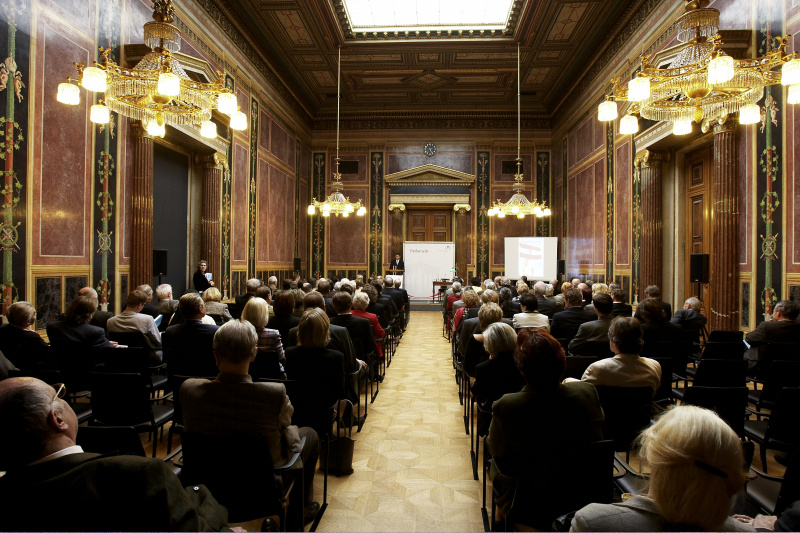 Der Zweite Nationalratspräsident am Rednerpult mit zuhörenden Veranstaltungsteilnehmern