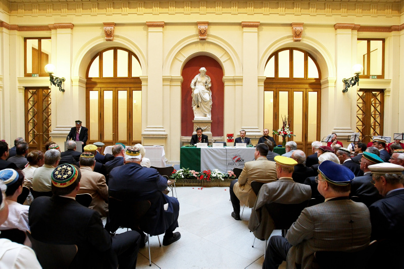 Blick in Richtung Veranstaltungsteilnehmer - v.li. am Podium Kartellsenior Peter J. Zehetner, Kartellphilistersenior RA Alexander Kragora und Kartellseelsorger Gabriel Reiterer, Kartellvorsitzender Helmut Schmitt am Rednerpult.