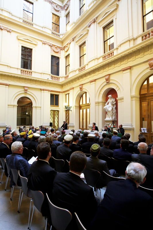 Blick in Richtung Veranstaltungsteilnehmer - v.li. am Podium Kartellsenior Peter J. Zehetner, Kartellphilistersenior RA Alexander Kragora und Kartellseelsorger Gabriel Reiterer,  Kartellvorsitzender Helmut Schmitt am Rednerpult.