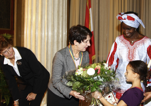 v.li. die UN Delegierte und Moderatorin der Veranstaltung Marlene Parenzan, Barbara Prammer erhält Blumen von einem kleinen Mädchen, die Präsidentin des EURONET FGM Netzwerkes Khady Koita.