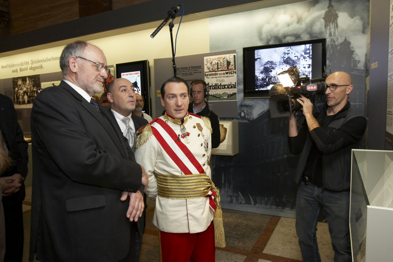 Kaiser Robert Heinrich I (Robert Palfrader - rechts)stattet der Ausstellung einen Besuch ab, durch das Parlament gefuehrt von Dr.Marckhgott (links)