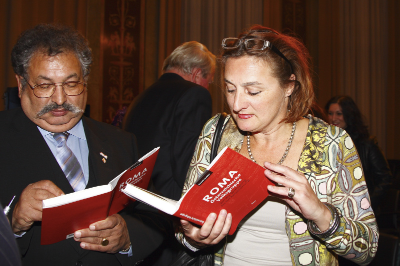 v.li. der Vorsitzende des Volksgruppenbeirates der Roma Rudolf Sarközi signiert ein Buch für eine Veranstaltungsteilnehmerin.