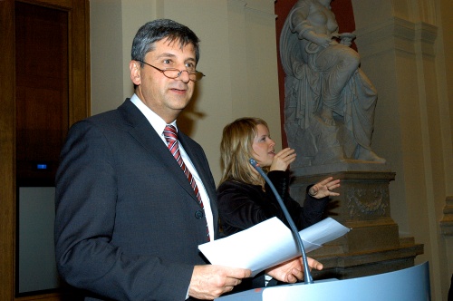Michael Spindelegger am Rednerpult, im Hintergrund eine Dolmetscherin für Gebärdensprache.