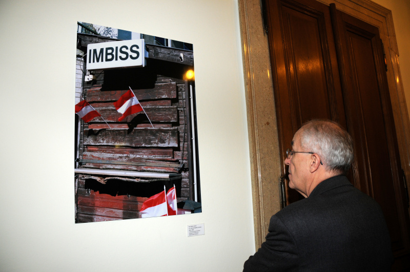 Ein Veranstaltungsteilnehmer betrachtet ein Foto. Künstler: Paul Albert Leitner.