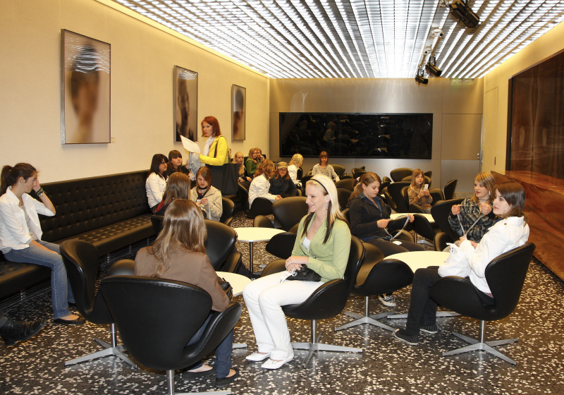 Schülerinnen warten im Pressezenrum auf den Beginn der Veranstaltung.