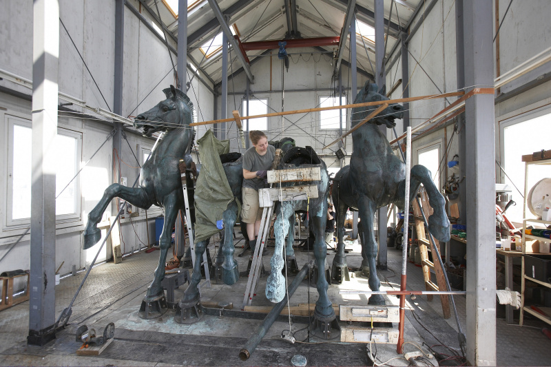 Reparaturarbeiten an der letzten Quadrige am Dach des Parlaments -Auftragen der Wachsschicht.