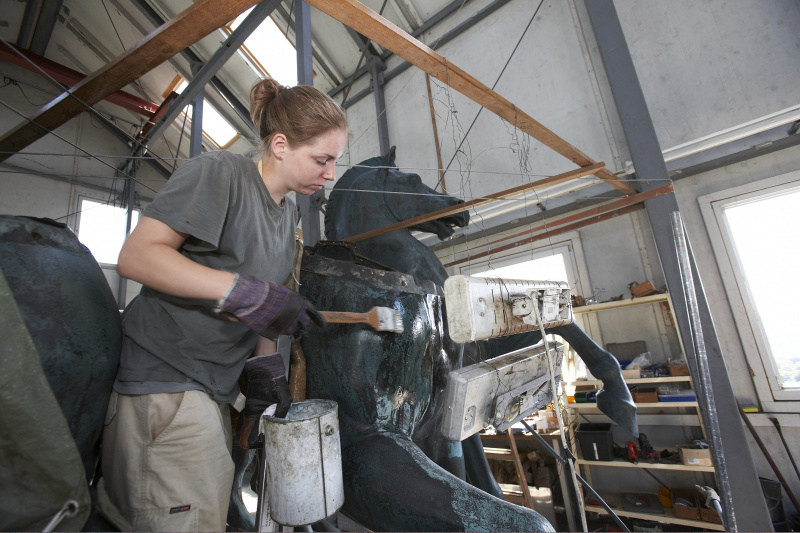 Reparaturarbeiten an der letzten Quadrige am Dach des Parlaments -Auftragen der Wachsschicht.