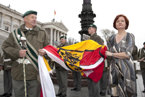 v.li.  Militaermusikkapelle Kaernten und Dr. Susanne Bachmann - Parlamentsdirektion - mit der Fahne Kaerntens