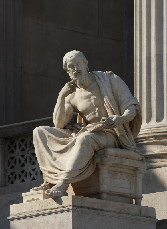 Darstellung des griechischen Geschichtsschreibers Herodot, mit aufgestütztem Haupt, Vollbart und Mantel bekleidet. Künstler Karl Schwerzek, 1898, Laaser Marmor. Von Ringstraßenseite links neben dem Brunnen.