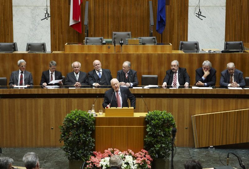Karl Blecha, Praesident des Österreichischen Seniorenrates am Rednerpult. Auf der Regierungsbank im Hintergrund v. li.: Dr. Gottfried Feurstein, Dr. Edwin Tiefenbacher, Josef Ratzenböck, Mag. Franz Karl, Dr. Andreas Khol, Dr. Alfred Zupancic, Werner Thum und Rudolf Edlinger.