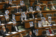 Buendnis Zukunft Oesterreich (BZOe) representatives hold up posters depicting the chairman of a parliamentary inquiry hearing Martin Bartenstein of the People's Party (OeVP) in the parliament in Vienna December 11, 2009. BZOe protest against the ending of the inquiry hearing. 'Abgedreht' reads 'turned off'. REUTERS/Heinz-Peter Bader
 ABDRUCK HONORARFREI NUR BEI DIREKTER BERICHTERSTATTUNG ZUR AUSSTELLUNG.