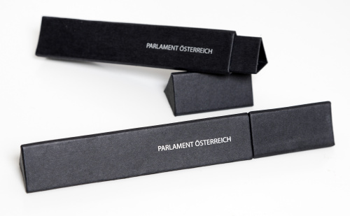 Dreieckige Geschenkverpackung aus Karton, schwarz mit Schriftzug Parlament Österreich in silber