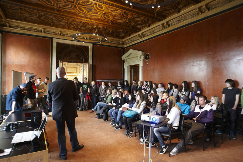 Moderator Andreas Baumgartner stellt den Jugendlichen der BHAK Feldkirchen, HLA fuer Mode und Kunst Wien sowie den Lehrlingen der ÖBB und der VOEST die Workshopleiter (im Hintergrund links) vor.