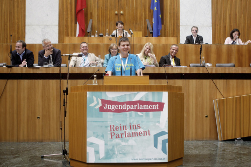 Schüler am Rednerpult präsentiert die Sitzungsergebnisse. Mag.a Barbara Prammer - Nationalratspräsidentin am Präsidium. Auf der Regierungsbank v.li. Mag. Michael Hammer - Nationalratsabgeordneter ÖVP, Dr. Josef Moser - Rechnungshofpräsident, Mario Kunasek - Nationalratsabgeordneter FPÖ, Dr. in Gabriela Moser - Nationalratsabgeordnete Grüne, Elisabeth Hakel - Nationalratsabgeordnete SPÖ und Stefan Petzner - Nationalratsabgeordneter BZÖ