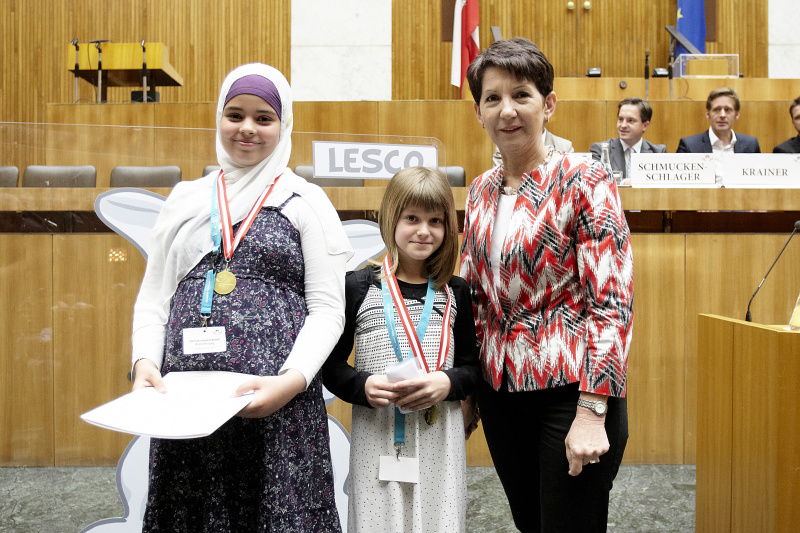 Nationalratspräsidentin Mag.a Barbara Prammer (re.) ehrt zwei Schülerinnen mit Urkunde und Medaillie
