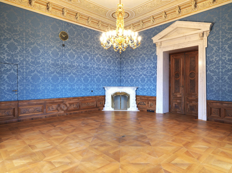 Boudoir der Dame mit blauer Stofftapete, die bei der Restaurierung im Jahr 2005 angebracht wurde und nicht ganz dem Original entspricht. Lamperie aus Holz und Furnieren, Ofen aus Carrara Marmor mit den Initialen der Familie Epstein.