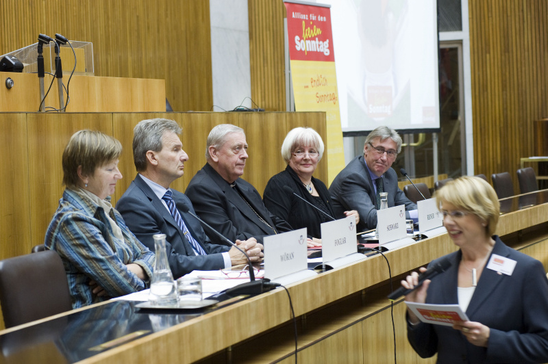 Am Podium v.li.: DSA Elisabeth Wöran, Geschäftsführerin der österreichischen Platform für Alleinerziehende, Erich Foglar - Präsident des österreichischen Gewerkschaftsbundes, Diözesanbischof Dr. Ludwig Schwarz - Sprecher der Allianz für den freien Sonntag, österreichische Bischofskonferenz, Dr.in Hannelore Reiner - geistliche Oberkirchenrätin Evangelische Kirche AB und Dr. Fritz Aichinger - Obmann der Sparte Handel der Wirtschaftskammer Österreich. Rechts im Bild Moderatorin Maria Ertl.