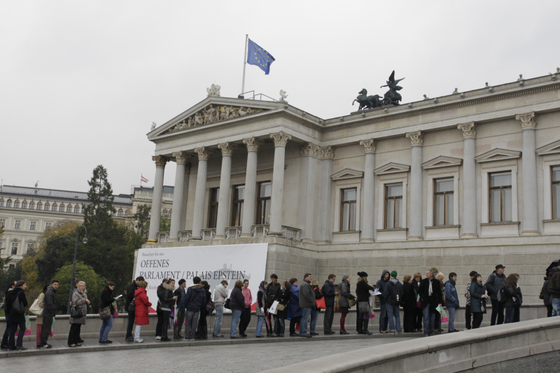 Besucherinnen und Besucher warten vor dem Parlamentsgebäude