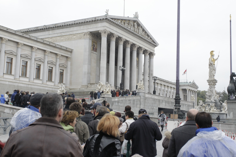 Besucherinnen und Besucher warten vor dem Parlamentsgebäude