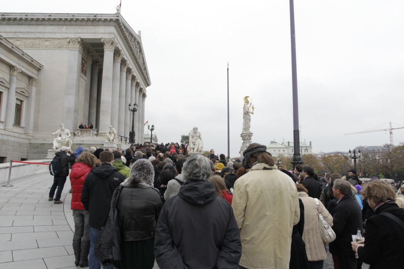 Besucherinnen und Besucher warten vor dem Parlamentsgebäude