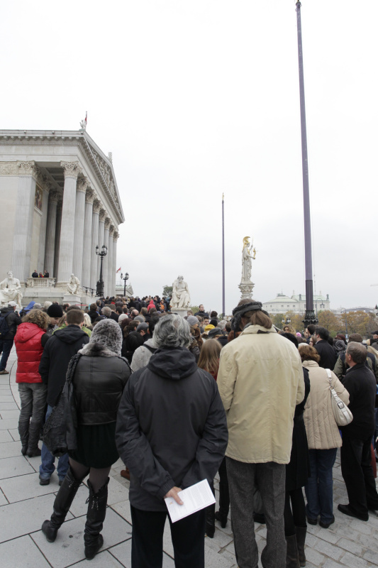 Besucherinnen und Besucher warten vor dem Parlamentsgebäude