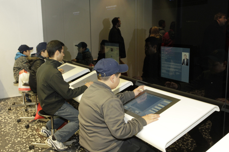 Besucherinnen und Besucher besichtigendie Medeienstationen im BesucherInnenzentrum