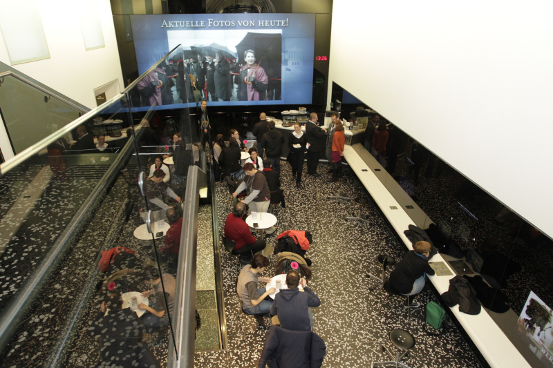 Besucherinnen und Besucher besichtigendie Medeienstationen im BesucherInnenzentrum