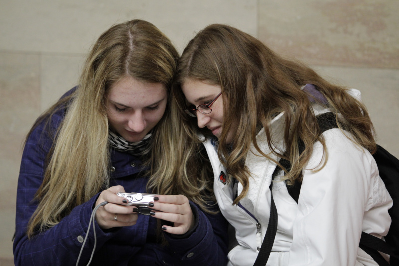 Zwei Besucherinnen betracht Fotos auf ihrer Digitalkamera