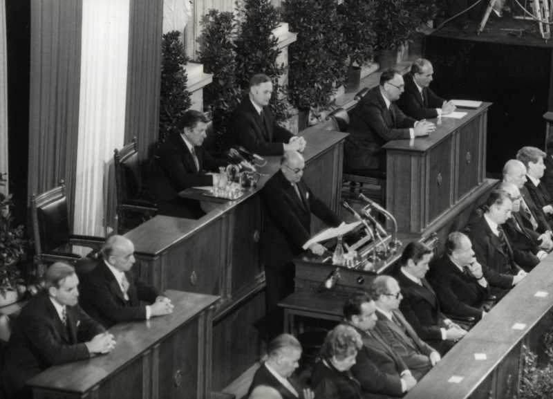 Blick auf das Präsidium und die Ministerbank während der gemeinsamen Festsitzung des NR und des BR am 12.11.1978 anlässlich 60 Jahren Republik.
Am Präsidium v.l.n.r.: BR-Vors. Stellvertreter Dr. Schambeck, III.Präsident des Nationalrates Probst, Präsident des Nationalrates Benya (am Rednerpult), Vorsitzender des Bundesrates Tratter, II. Präsident Minkowitsch, BR-Vors. Stellvertreter Dr. Skotton und Parlamentsdirektor Dr. Czerny.
Auf der Ministerbank v.l.n.r.: die Bundesminister Rösch, Firnberg, Sinowatz, Pahr, Vizekanzler Androsch, Bundeskanzler Kreisky, die Bundesminister Lanc, Broda, Weissenberg und Leodolter.