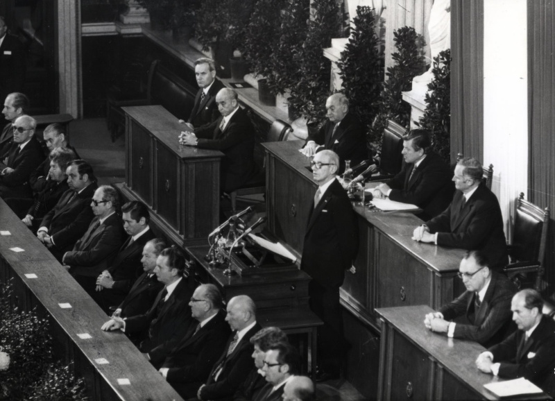 Blick auf das Präsidium und die Ministerbank während der gemeinsamen Festsitzung des NR und des BR am 12.11.1978 anlässlich 60 Jahren Republik.
Am Präsidium v.l.n.r.: BR-Vors. Stellvertreter Dr. Schambeck, III.Präsident des Nationalrates Probst, Präsident des Nationalrates Benya, Vorsitzender des Bundesrates Tratter, II. Präsident Minkowitsch, BR-Vors. Stellvertreter Dr. Skotton und Parlamentsdirektor Dr. Czerny.
Auf der Ministerbank v.l.n.r.: Staatssekretär Nussbaumer, die Bundesminister Staribacher, Rösch, Firnberg, Sinowatz, Pahr, Vizekanzler Androsch, Bundeskanzler Kreisky, die Bundesminister Lanc, Broda, Weissenberg, Leodolter, Haiden und Lausecker.
Am Rednerpult: Bundespräsident Rudolf Kirchschläger.