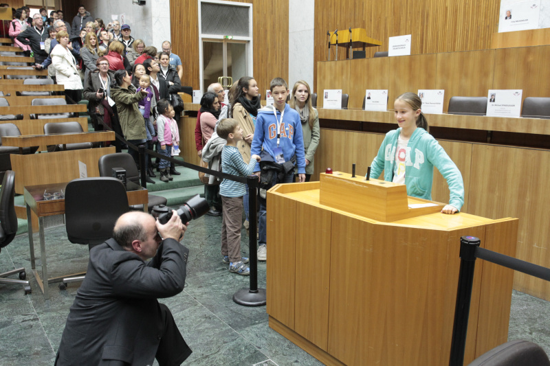 Besucherinnen und Besucher lassen sich am Rednerpult des Nationalrates fotografieren