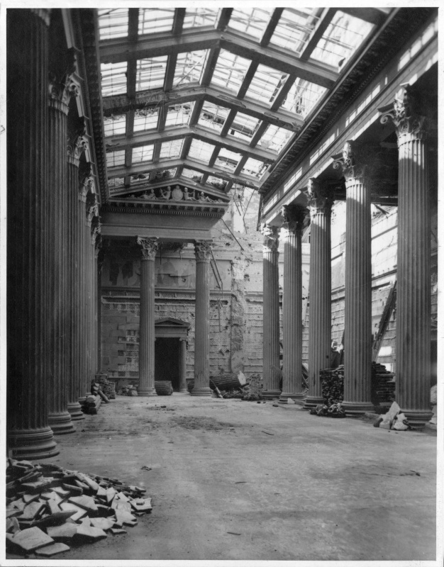 Blick in die durch einen Bombentreffer schwer beschädigte Säulenhalle. Die schwersten Gebäudeschäden erfolgten durch Bombentreffer am 7. und 21. Februar 1945 sowie durch Kampfhandlungen bei der Befreiung Wiens durch die Rote Armee. Gelegte Brände durch abziehende NSDAP-Bedienstete (Verbrennung von Akten).