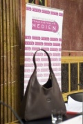 Feature Handtasche vor Plakat des Frauennetzwerk Medien