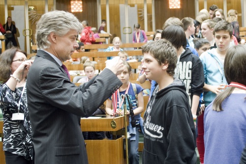 Parlamentsdirektor Harald Dossi überreicht den SchülerInnen die  Medaillen
