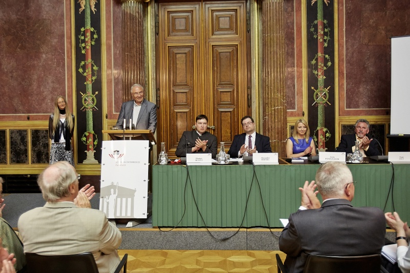 Gerhard Zheisel am Rednerpult mit der Laudatio für die zu ehrende Christiane Tumberger (li.). Podium v.li.: Historiker Florian Rulitz, Alexander Höferl, Ania Pendzialek und Zeitzeuge Ivan Ott