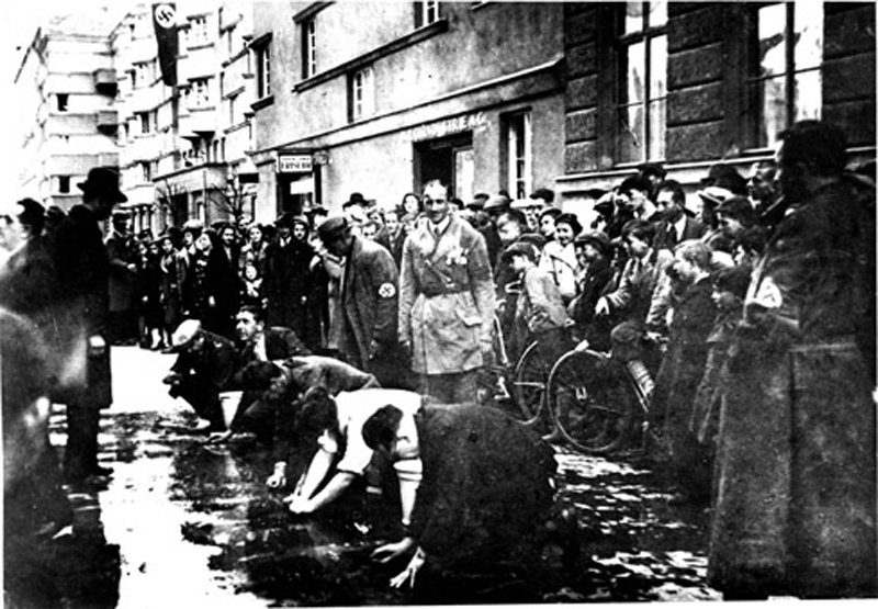 Juden, die gezwungen wurden, die Straße von politischen Parolen zu säubern