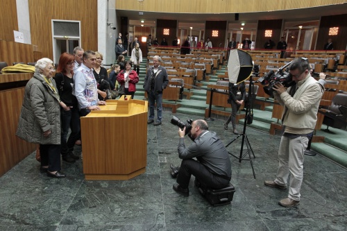 BesucherInnen können sich am Rednerpult im Nationalratssitzungssaal fotografieren lassen