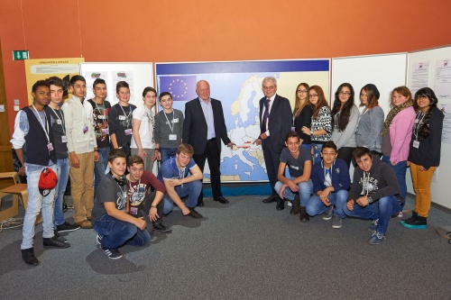 Gruppenfoto mit SchülerInnen. In der Bildmitte die Europaabgeordneten Josef Weidenholzer (S, links) und Heinz Becker (V, rechts)