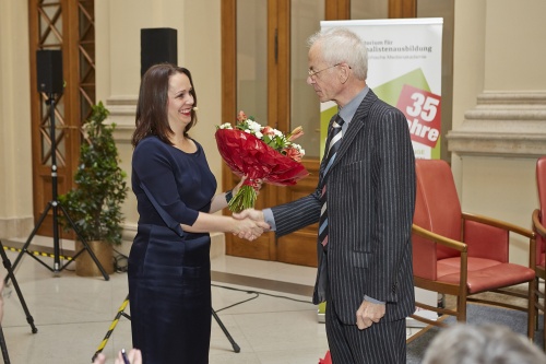 Der Gründungsgeschäftsführer des Kuratoriums für Journalistenausbildung Heinz Pürer überreicht einen Blumenstrauß an Elisabeth Wasserbauer