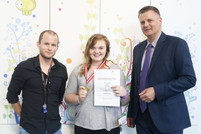 v.re.: Dienstleiter für Öffentlichkeitsarbeit Rudolf Gollia, Schülerin Michelle Krenn und Lehrer Philipp Brunner bei der Urkunden- und Medaillenübergabe