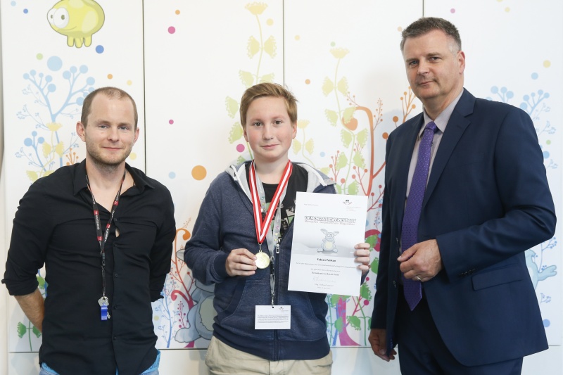 v.re.: Dienstleiter für Öffentlichkeitsarbeit Rudolf Gollia, Schüler Fabian Pelikan und Lehrer Philipp Brunner bei der Urkunden- und Medaillenübergabe