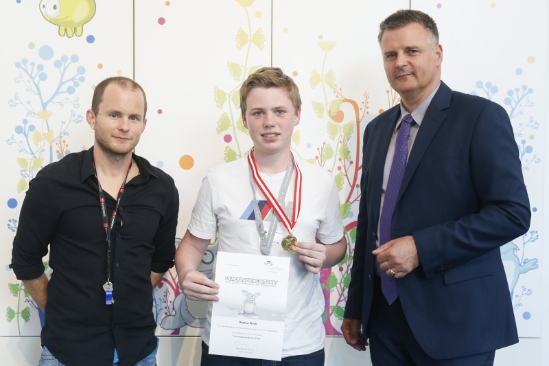 v.re.: Dienstleiter für Öffentlichkeitsarbeit Rudolf Gollia, Schüler Thomas Ploch und Lehrer Philipp Brunner bei der Urkunden- und Medaillenübergabe