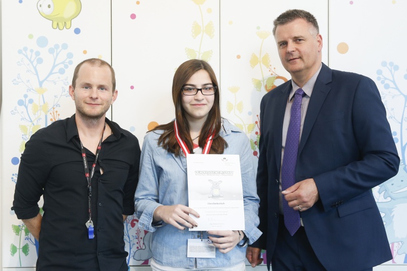 v.re.: Dienstleiter für Öffentlichkeitsarbeit Rudolf Gollia, Schülerin Clara Barboritsch und Lehrer Philipp Brunner bei der Urkunden- und Medaillenübergabe